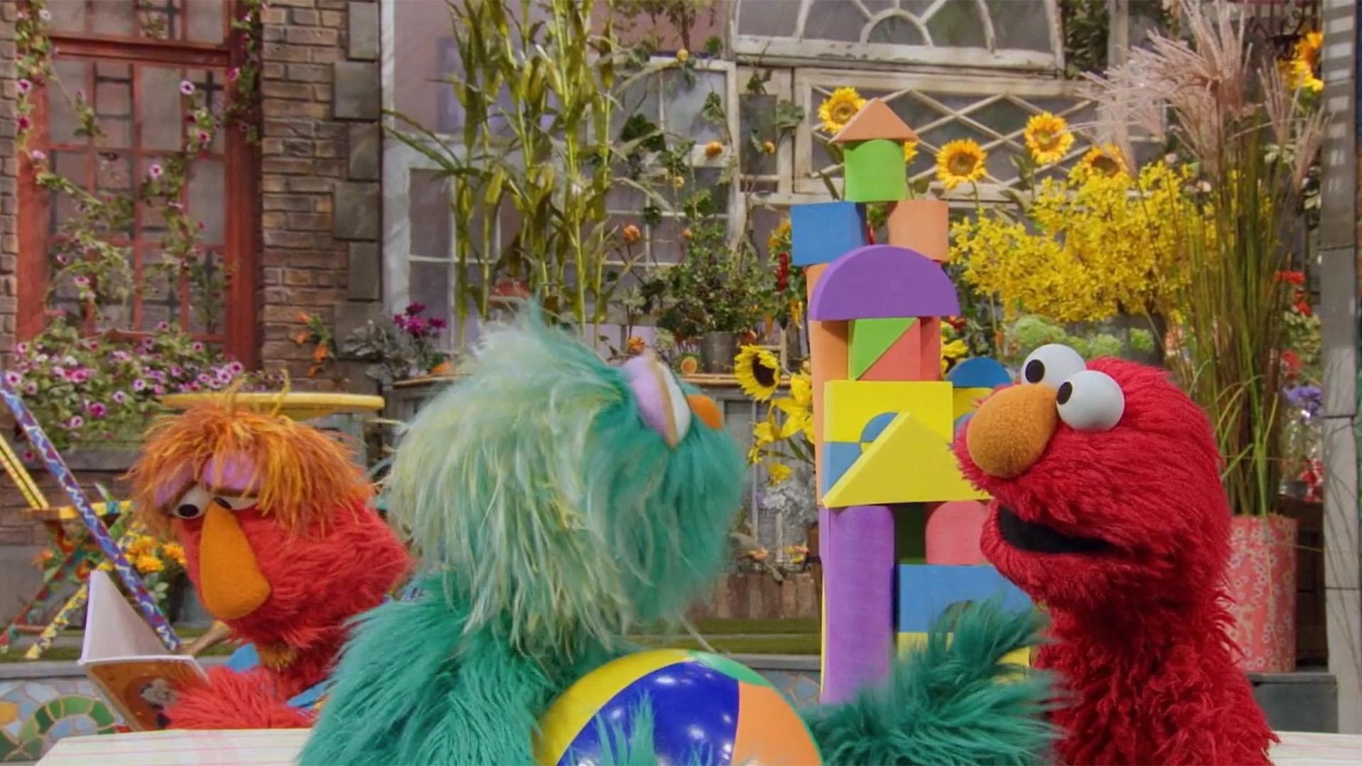 Elmo accidentally knocks over his block tower during a game of Beachball Bop.